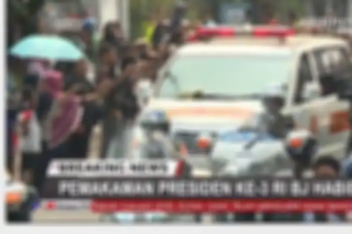 Masyarakat sepanjang jalan mengabadikan momen iring-iringan mobil jenazah BJ Habibie.