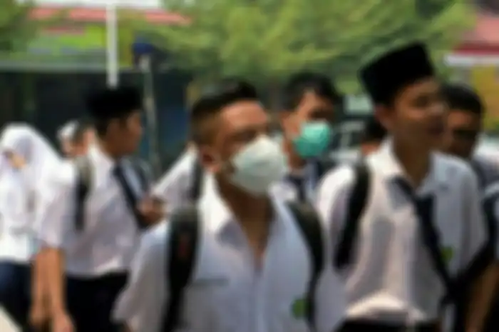 Siswa yang pergi ke sekolah diwajibkan pakai masker.