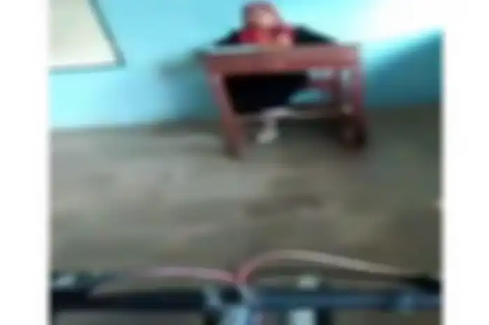 Siswa main sepeda di dalam kelas saat guru mengajar.  