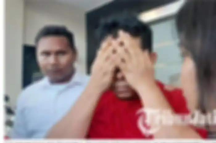 Rudi menutupi mukanya di Mapolrestabes Surabaya  