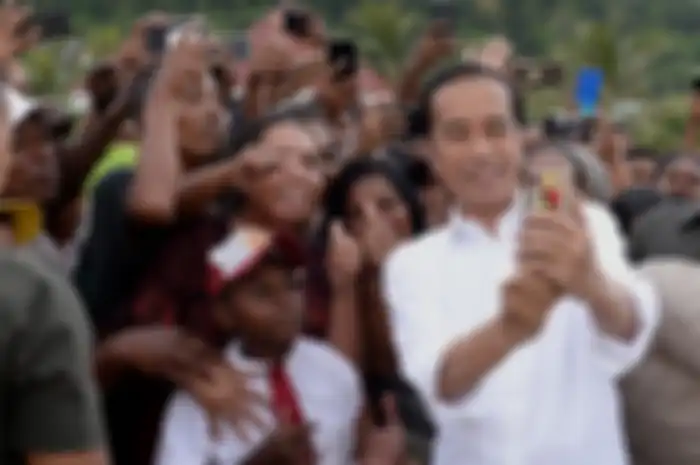 Presiden Joko Widodo atau akrab disapa Jokowi, berswafoto bersama warga yang menyambut kunjungannya di Kabupaten Kaimana, Papua Barat, Minggu (27/10/2019). Dalam kunjungannya, Jokowi dan Ibu Negara Iriana menikmati senja di Kaimana dengan duduk di tepi anjungan Laut Arafuru saat langit mulai memerah