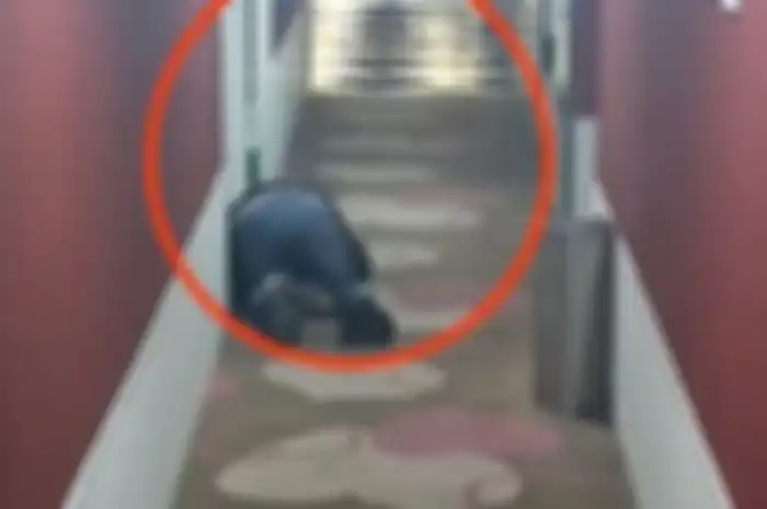 Seorang pria di China bernama He nampak berjongkok di depan kamar hotel dan mendengarkan pasangan berhubungan seks di dalamnya.