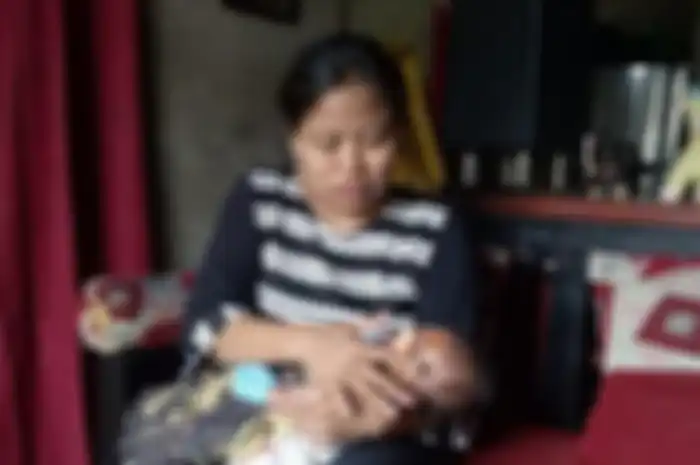 Lisdawati (40) ibunda AP sedang merawat bayi perempuannya usai pulang dari rumah sakit