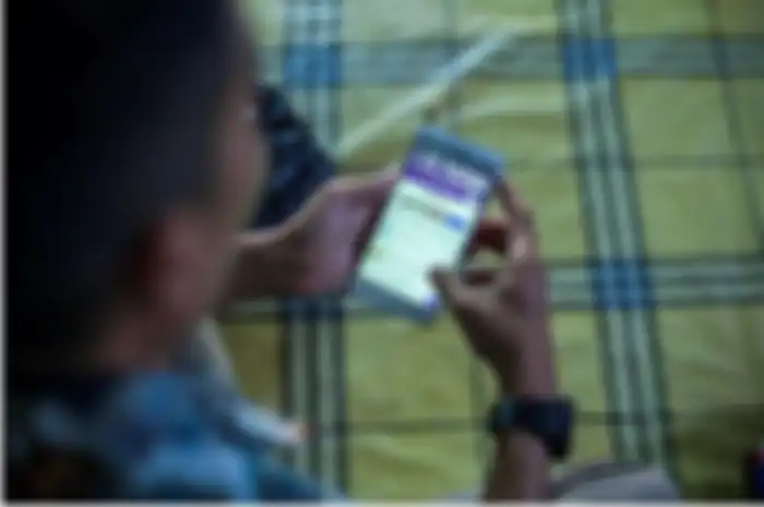 Dodi, 27, penjual barang daring mengakses Forum Jual Beli Natuna (FJBN)  yang ada di Facebook melalui gawainya di Kota Ranai, Pulau Natuna, Kepulauan Riau, Rabu, 9 Oktober 2019.  Forum ini merupakan salah satu saluran jual beli daring yang terbesar di Natuna dengan jumlah anggota mencapai lebih dari