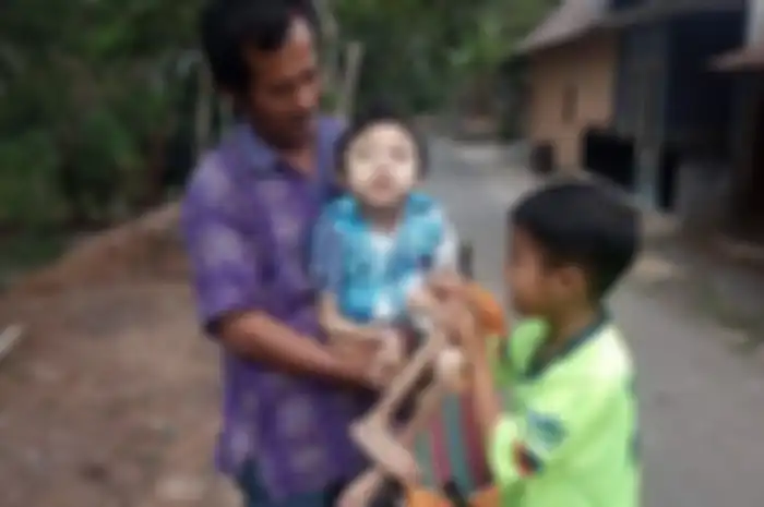 Dimas, berusia 12 tahun diegndong oleh Ramelan