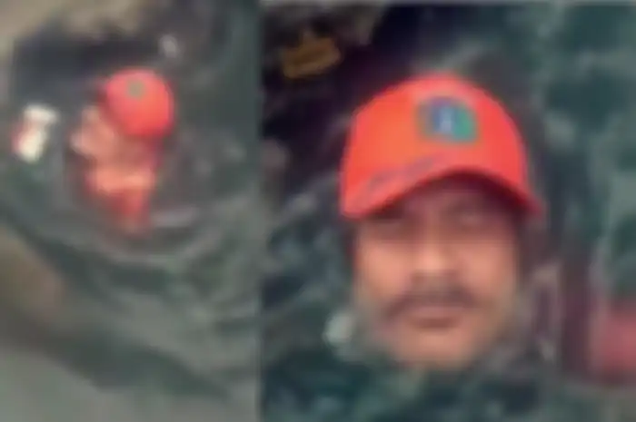 Seorang Anggota PPSU menyelam mengambil sampah yang menutup selokan di tengah hujan deras dan banjir