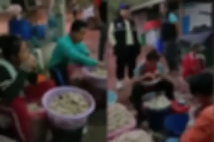Para karyawan di sebuah pabrik Thailand menggunakan mulutnya untuk memisahkan tulang di ceker ayam