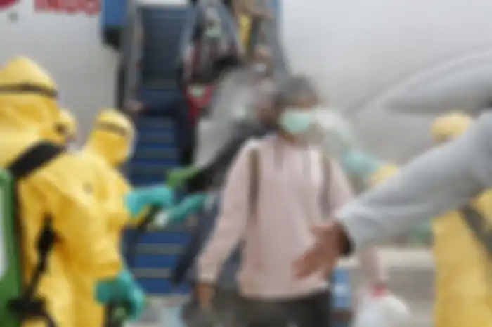 Petugas medis menyemprotkan cairan disinfektan pada warga negara Indonesia (WNI) dari Wuhan, China setibanya di Bandara Hang Nadim, Batam, Kepulauan Riau, Minggu (2/2/2020). Sebanyak 238 WNI dari Wuhan tersebut selanjutnya dipindahkan ke Natuna untuk menjalani observasi selama kurang lebih dua minggu guna memastikan kesehatannya dan terbebas dari virus corona.