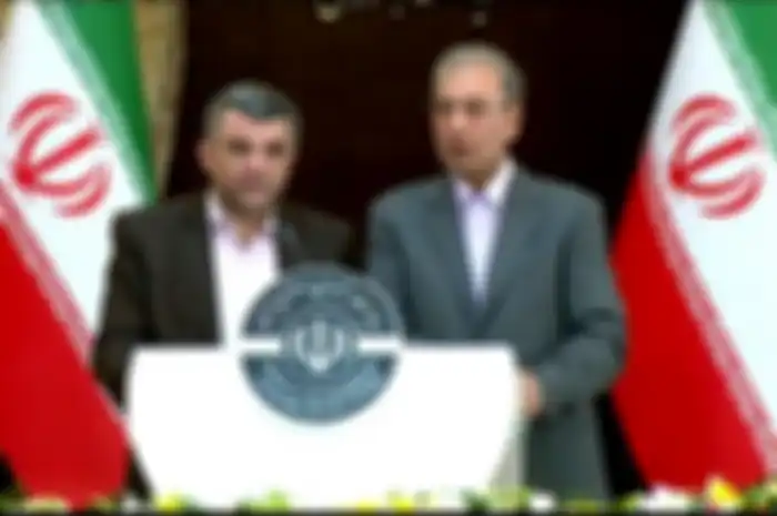  Foto yang dirilis oleh kantor berita Iran Press pada 24 Februari menunjukkan juru bicara pemerintah Ali Rabiei (kanan) dan Wakil Menteri Kesehatan Iraj Harirchi mengadakan konferensi pers. Sehari kemudian, Harirchi mengumumkan dia terkena virus corona setelah di jumpa pers, dia berkeringat dan terlihat tidak nyaman.