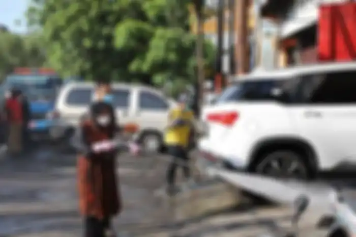 Walikota Surabaya Tri Rismaharini menyemprot disinfektan di jalanan, tindakan yang dianggap sia-sia oleh WHO.