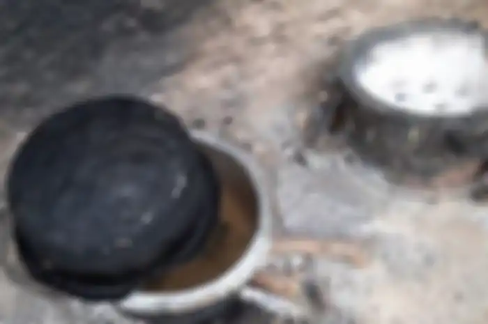 Peninah Bahati Kitsao janda 8 anak menempatkan batu di tungku agar kelihatan memasak oleh anak-anaknya. Ia berharap anak-anaknya tertidur saat menanti makanan-nya selesai dimasak.