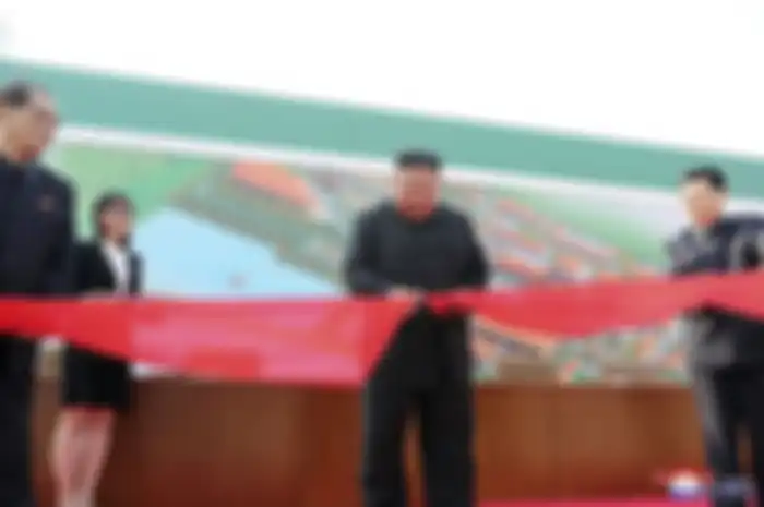 Kim Jong Un sedang melakukan pemotongan pita merah untuk peresmian pabrik pupuk