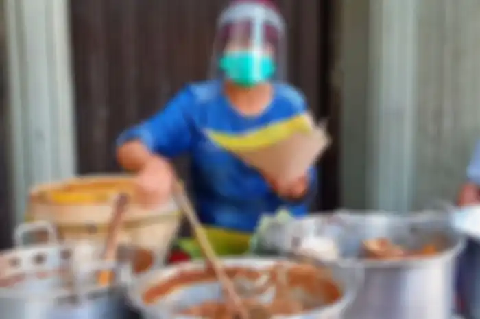 Sudarmi, penjual gudeg di Jalan Urip Sumoharjo, kota Yogyakarta yang berjualan dengan mengenakan masker dan face shield. Hal ini dilakukanya untuk melindungi diri dan pembeli ditengah pandemi Covid-19.