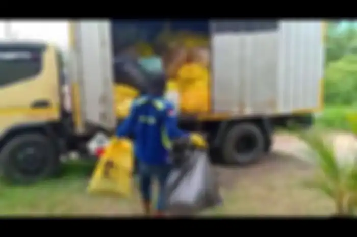 Petugas sedang memasukan sampah masker ke dalam truk di Gudang Dinas LH, Bambu Larangan, Cengkareng Barat, Jakarta Barat  