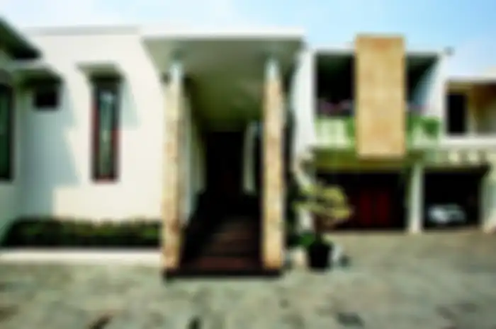 Kanopi di pintu masuk dan balkon berperan jadi secondary skin di rumah tropis ini. 
