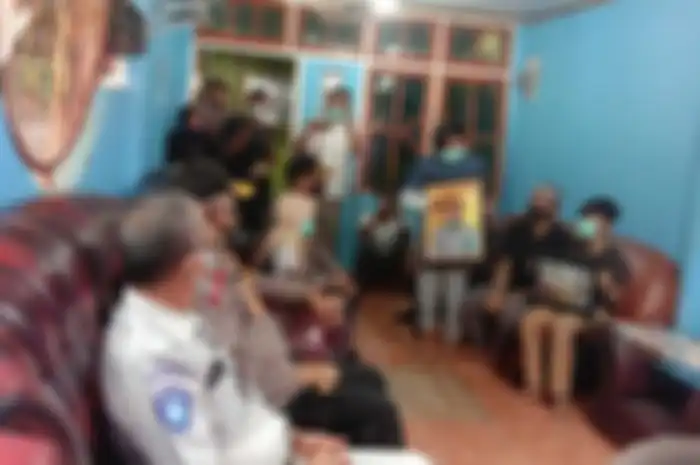 Rasya (berdiri) putra sulung Bripka Christin Meisye Batfeny terisak memegang foto sang ibu