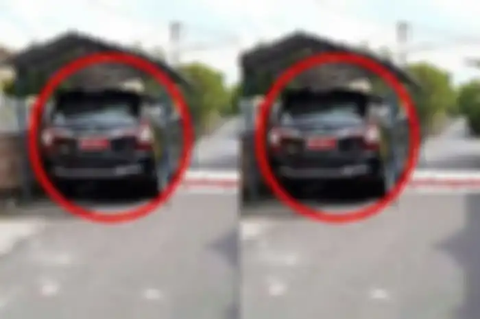 Viral foto mobil plat merah diparkirkan di sebuah garasi yang memotong jalan.