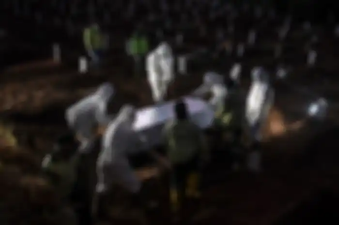 Foto dirilis Sabtu (19/9/2020), memperlihatkan petugas penggali makam jenazah Covid-19 menurunkan peti ke dalam liang lahat di kompleks pemakaman Pondok Ranggon. Selain tenaga medis yang menjadi garda terdepan penanganan virus corona, salah satu pahlawan lain juga patut diberikan apresiasi tinggi