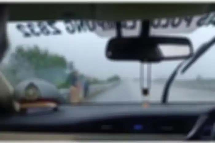 Ibu dan dua anak kecil saat terlihat berjalan di bahu jalan tol Lampung. 