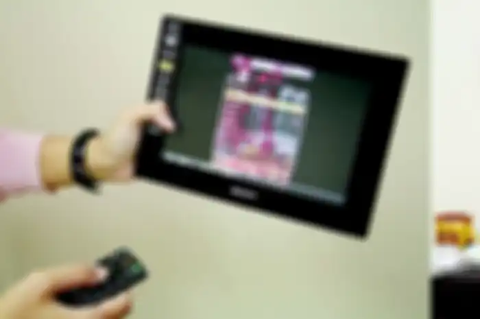 Pengoperasian digital photo frame dengan remote dan tampil seperti tablet.