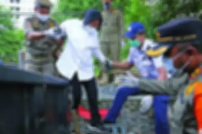 Mensos Risma dibantu petugas menapaki tangga turun ke bantaran Kali Ciliwung, Jakarta, untuk menyapa dan berbincang dengan gelandangan dan pemulung, Senin (28/12/2020). 