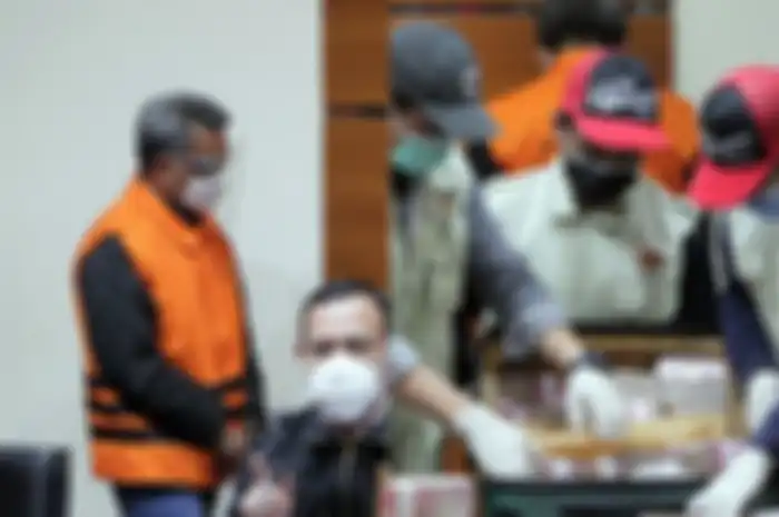 Nurdin Abdullah dan barang bukti uang yang diduga hasil dari korupsi pengadaan infrastruktur.