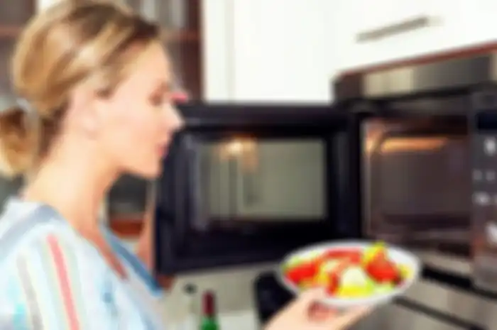 Ilustrasi penggunaan microwave di dapur.