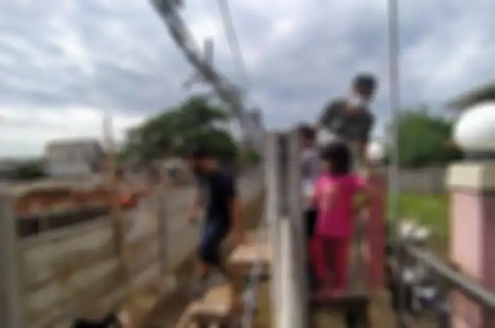 Anton dan keluarga mesti menggunakan kursi untuk keluar dari akses rumah yang ditemboki Ruli.