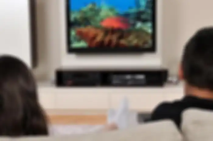 Ilustrasi milenial bermain game di rumah melalui smart tv. 