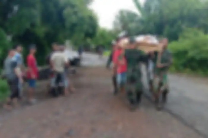TNI dan warga menggotong seorang warga yang jadi korban banjir di wilayah Ile Ape, Kabupaten Lembata, Minggu 4 April 2021. 