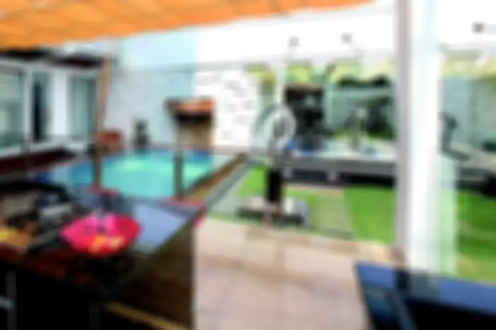 Dapur dibuat di luar ruang, menghadap kolam renang, taman, dan ruang kebugaran.
