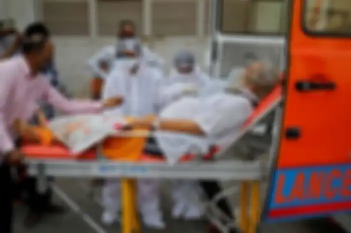 Pasien lansia terinfeksi Covid-19 di India dibawa mobil ambulance.