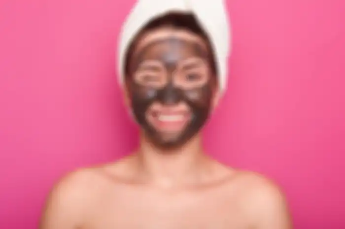 Ilustrasi seorang wanita sedang menggunakan masker wajah.
