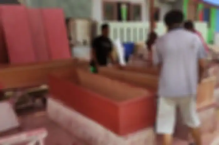 Aris bersama rekannya yang bekerja sebagai perajin peti jenazah di bawah naungan CV. Sahabat Duka yang berlokasi di sudut TPU Pondok Kelapa, Jakarta Timur, Rabu (7/7/2021). 