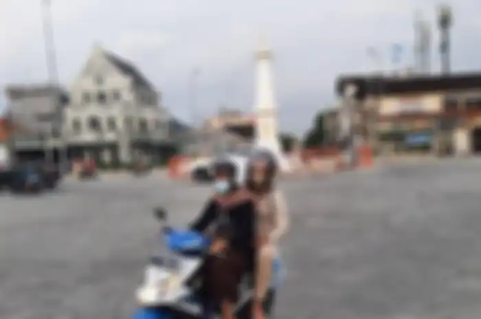 Pengendara sepeda motor yang melintas di Tugu Pal Putih Yogyakarta taat prokes dengan mengenakan masker, Minggu (24/1/2021) 