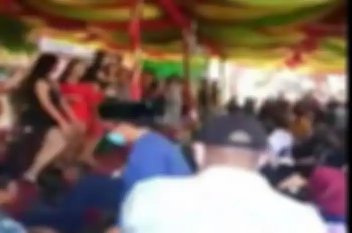Camat Pendopo Sapardina Joli (pakai peci bermasker) menaiki panggung untuk menyampaikan imbauan dan pembubaran acara kontes waria yang timbulkan keramaian di Desa Nanjungan, Kecamatan Pendopo, Kabupaten Empat Lawang, Jumat (23/7/2021)