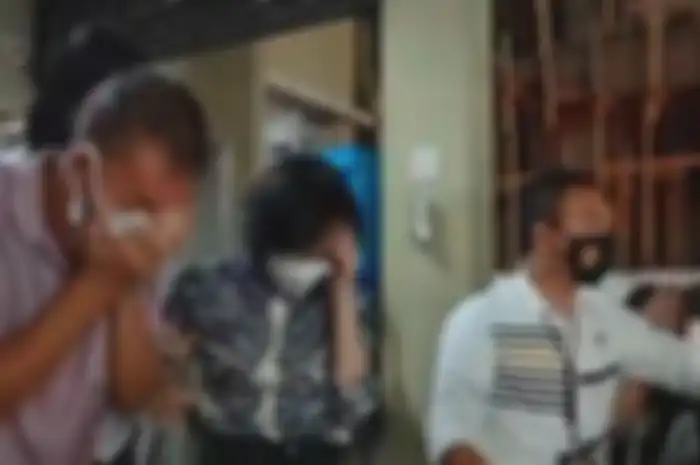Heriyanti bersama suami dan anak-laki-lakinya keluar dari gedung Ditreskrimum Polda Sumsel 