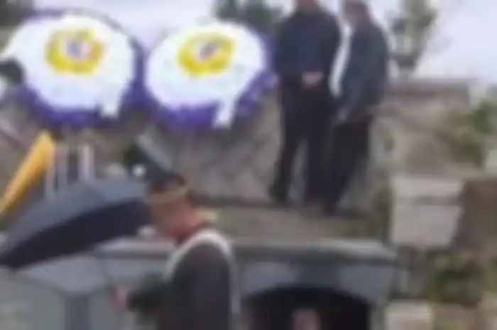 Seorang perempuan menangis di depan kuburan ayah mertuanya. Dia menghalangi ayah mertuanya dimakamkan karena tak dapat warisan yang banyak