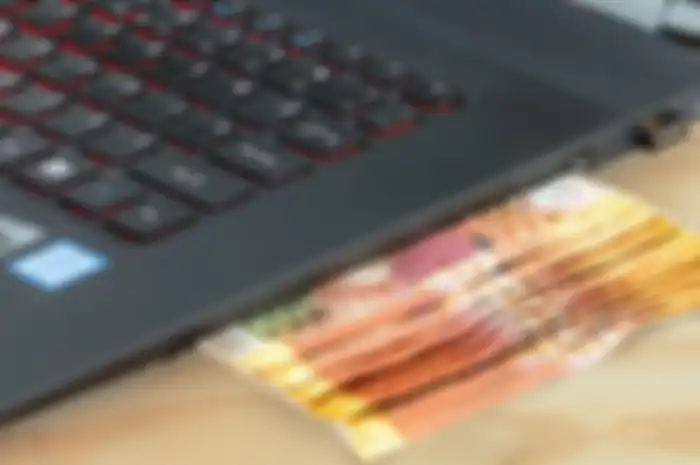 Ilustrasi uang keluar dari laptop