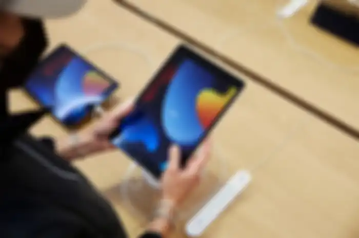 Pengunjung Apple Store mencoba mengoperasikan iPad 9