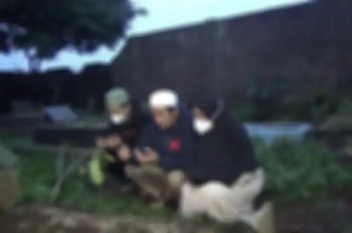 Mimin Mintarsih (51) (kanan) serta kedua anaknya saat menyambangi makam dari kedua korban di Pemakaman Umum Istuning, Desa Jalancagak, Kecamatan Jalancagak, Kabupaten Subang, Senin (27/9/2021). 