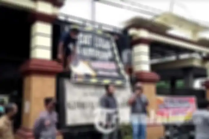 Warga Aryojeding, Kecamatan Rejotangan, Tulungagung, memasang spanduk memprotes kepala desa yang dituding selingkuh, Senin (20/12/2021).  