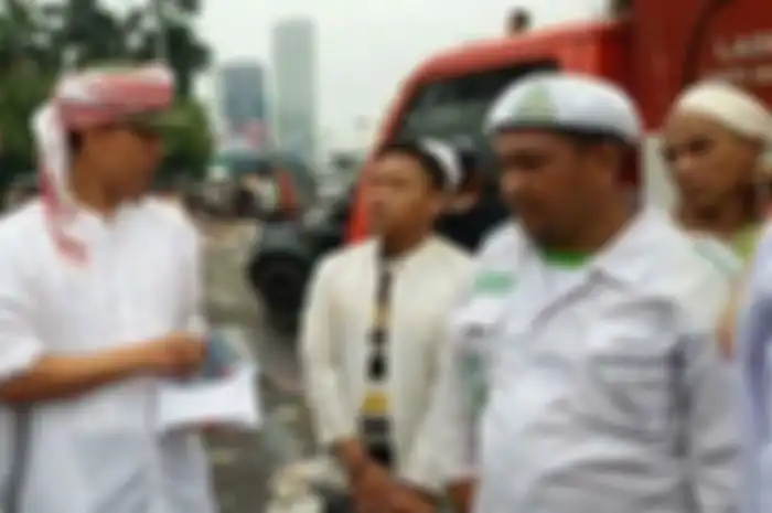 Foto Munarman pegang uang di depan peserta demo terlihat sebagai dokumentasi dari sebuah acara unjuk rasa yang pernah digelar. 