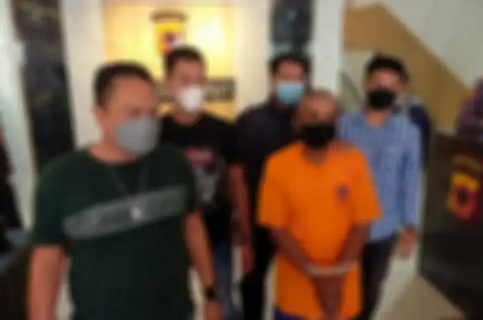 OS (63), kakek yang berusaha melakukan pencabulan terhadap bocah berusia 9 tshun saat digiring aparat kepolisian Polres Garut.