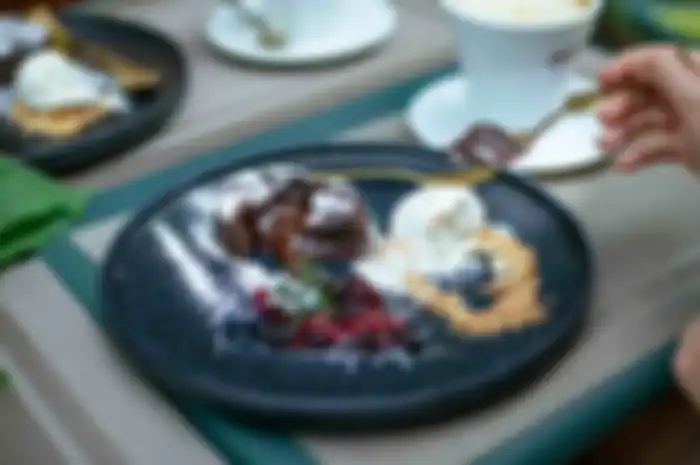 Potret seseorang sedang menyantap dessert atau makanan penutup.