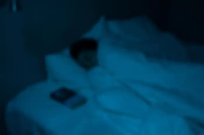 Ilustrasi seseorang tertidur di malam hari.