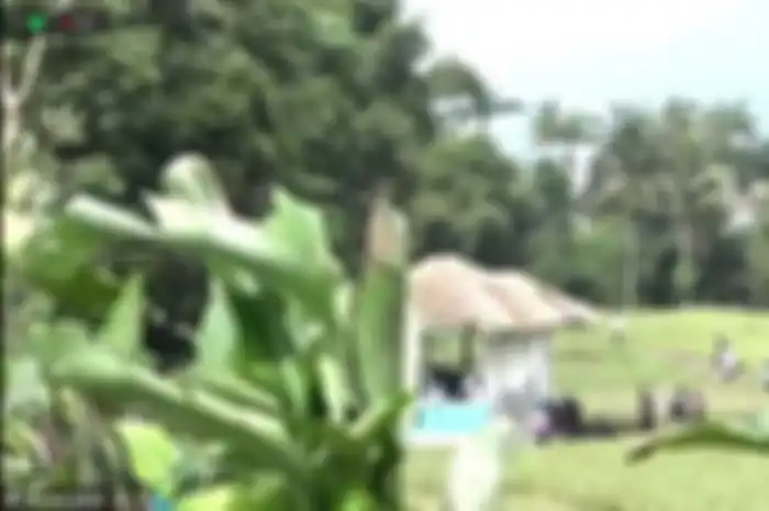 Warga rela berdiri di tengah sawah dekat lokasi pemakaman jenazah Eril