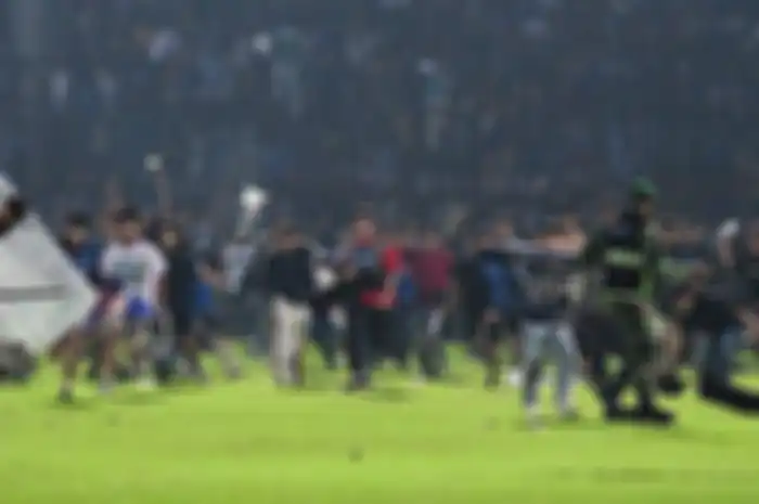Suporter Arema FC, Aremania menerobos ke dalam lapangan usai Arema FC dikalahkan Persebaya Surabaya dengan skor 2-3 dalam laga lanjutan Liga 1 2022 di Stadion Kanjuruhan, Malang, Sabtu (1/10/2022).  