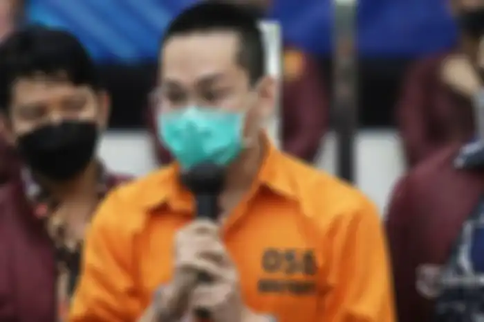 Potret Indra Kenz mengenakan baju tahanan