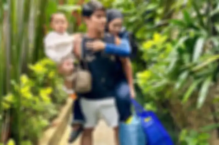 Rizky Billar gendong sosok anak dan istri, Lesti Kejora sambil tenteng tiga tas.